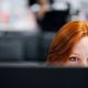 mujer tras pantalla en oficina